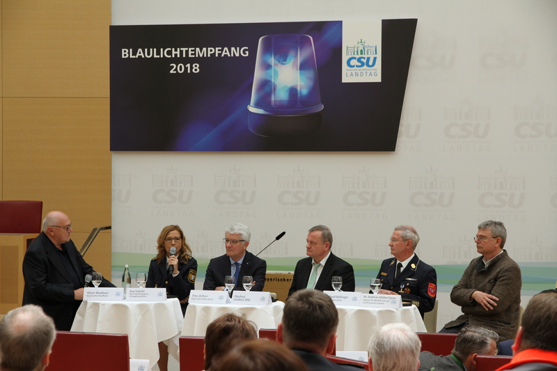 Oliver Bendixen, Polizeireporter des Bayerischen Rundfunk, begrüßte auf dem Podium Eva Schichl, Dienststellenleiterin der Polizeiinspektion Augsburg-Mitte, Theo Zellner, den Präsidenten des Bayerischen Roten Kreuzes, Manfred Ländner, MdL, den Vorsitzenden des Arbeitskreises für Kommunale Fragen, Innere Sicherheit und Sport, Ehrenkreisbrandrat Gerhard Bullinger sowie Dr. Andreas Müller-Cyran, Experte für Notfallseelsorge und Krisenintervention (v.l.n.r.). | © CSU-Fraktion 